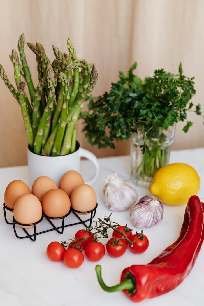 A selection of fresh ingredients including asparagus, eggs, and more for healthy cooking.