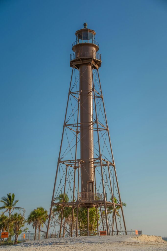 Beautiful lighthouse on a sunny beach with palm trees, perfect for travel and maritime themes.